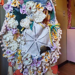 Upcycled handmade shoulder bag with fabric flowers and fuzzy pink back.